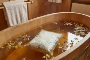 Bio-Heublumenbad in rustikaler Holzwanne mit einer Bio Heublumen Packung